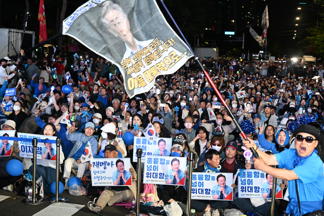 4일 서울 여의도 국회 인근에서 더불어민주당 주최로 열린 제21대 대통령 선거 프리미어토토개표방송 행사에 참석한 시민들이 방송예측시스템에서 이재명 대선 후보의 ‘당선 확실’이 나오자 환호하고 있다.  [연합]