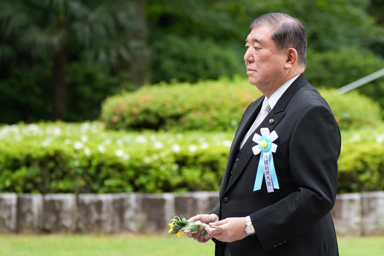 Japan's Prime Minister Shigeru Ishiba offers a flower during a ceremony to pay respects to unidentified war dead who died during World War II at the Chidorigafuchi National Cemetery in Tokyo on May 26. (AFP)
