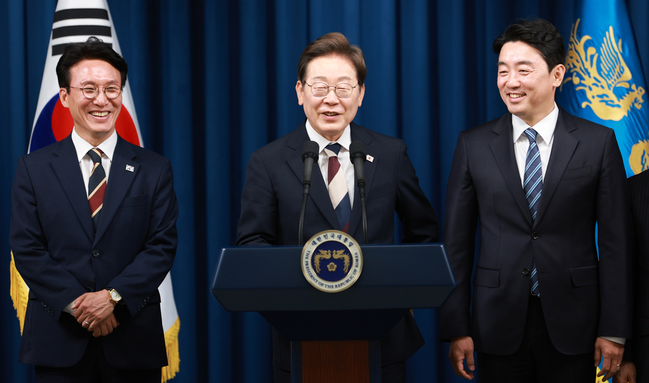 Lee Jae-myung (center) laughs during his first press conference as president on Wednesday at the presidential office in Seoul to announce key nominations for his administration, including Prime Minister nominee Rep. Kim Min-seok (left) and Presidential Chief of Staff Kang Hoon-sik. (Yonhap)