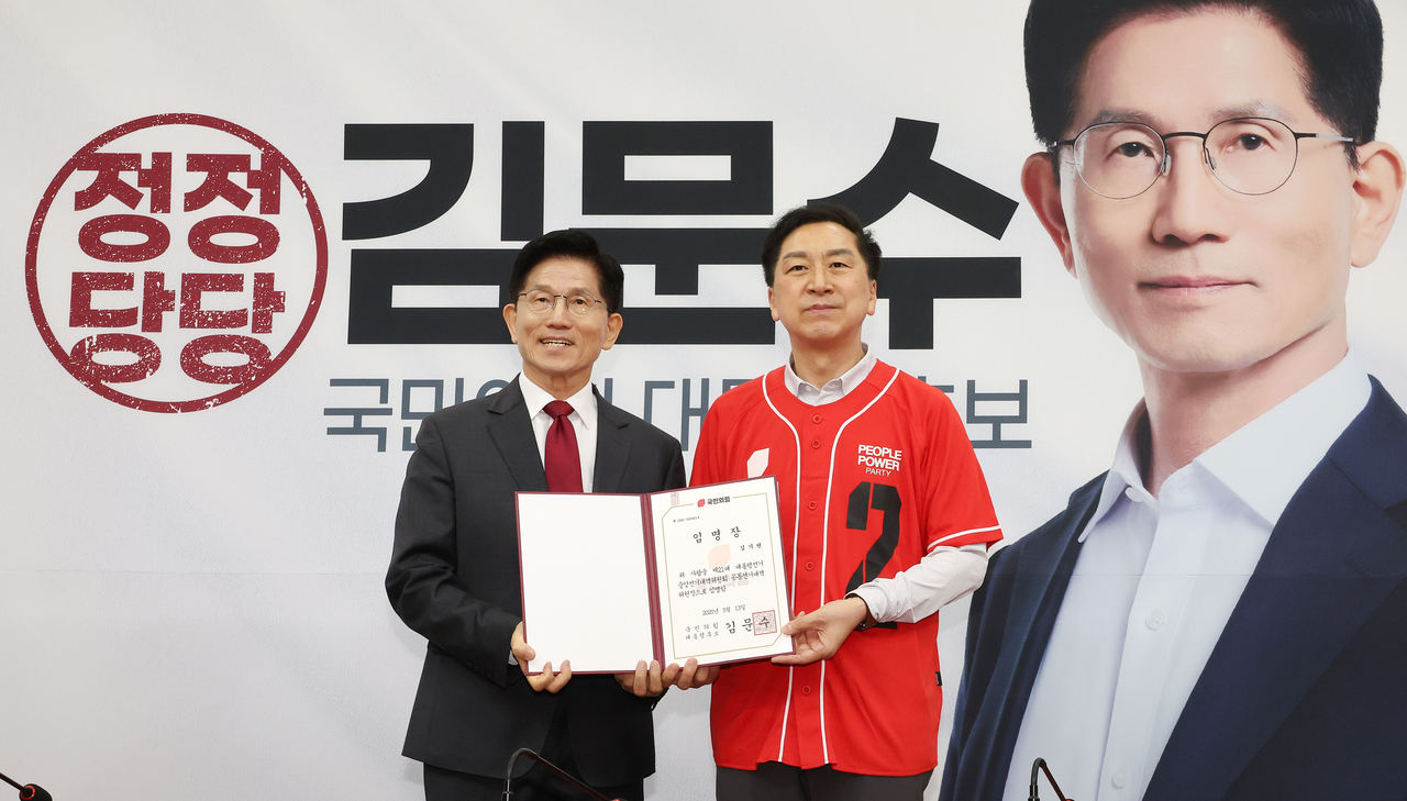 국민의힘 김문수 대선 후보(왼쪽)가 15일 국회에서 열린 중앙선거대책위원회 회의 및 임명장 수여식에서 김기현 공동선대위원장에게 임명장을 전달한 뒤 기념 사진을 촬영하고 있다. [연합]