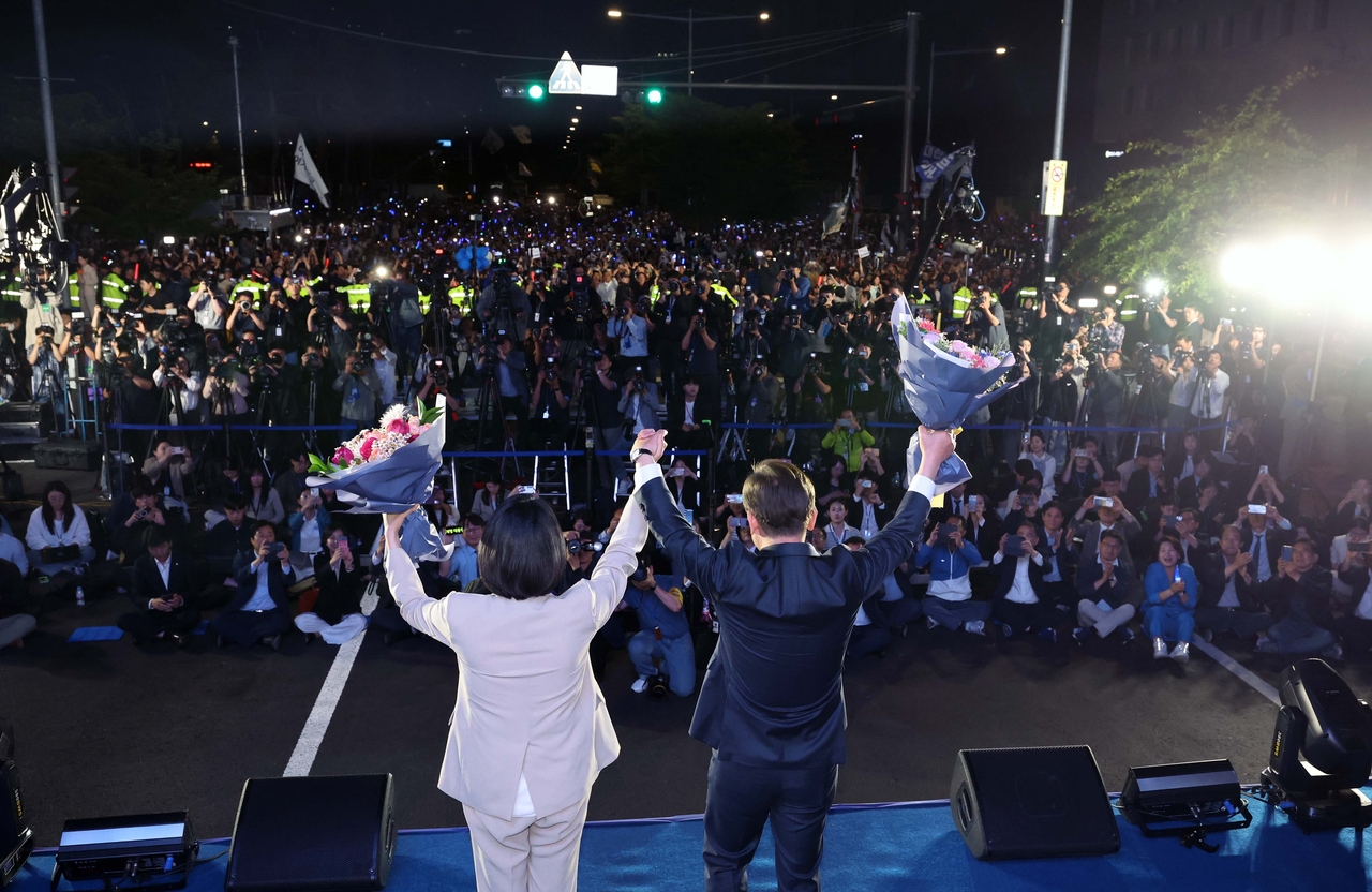 제21대 대통령 당선이 확실시되는 더불어민주당 불야성 토토사이트 대선 후보와 부인 김혜경 여사가 4일 서울 여의도 국회 인근에서 당 주최로 열린 국민개표방송 행사에 참석해 꽃다발을 받고서 시민들을 향해 두 팔을 들어 인사하고 있다. [연합]