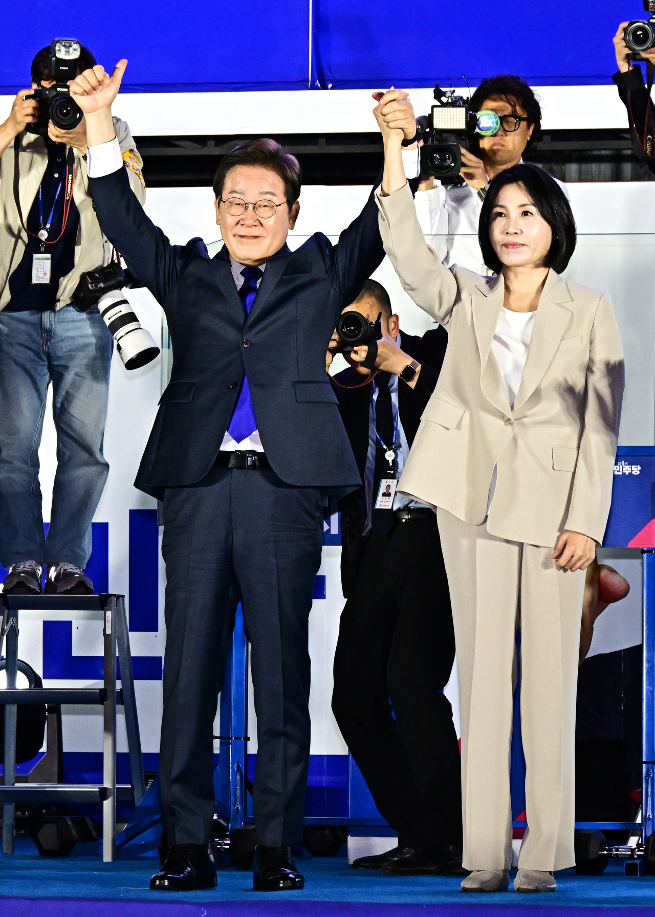 이재명 대통령이 부인 김혜경 여사와 4일 새벽 서울 여의도 국회 인근에서 당 주최로 열린 국민개표방송 행사에 참석해 시민들을 향해 인사하는 모습. <연합>