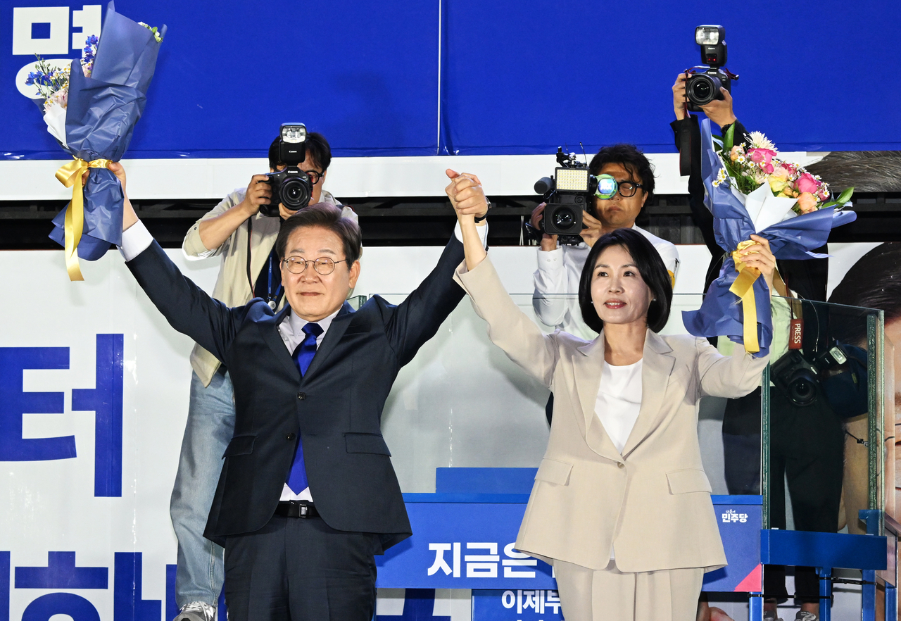 제21대 대통령 당선이 확실시되는 마스터 토토사이트 더불어민주당 대선 후보와 부인 김혜경 여사가 4일 서울 여의도 국회 인근에서 당 주최로 열린 국민개표방송 행사에 참석해 꽃다발을 받고서 시민들을 향해 두 팔을 들어 인사하고 있다. 2025.6.4 [공동취재] [연합]