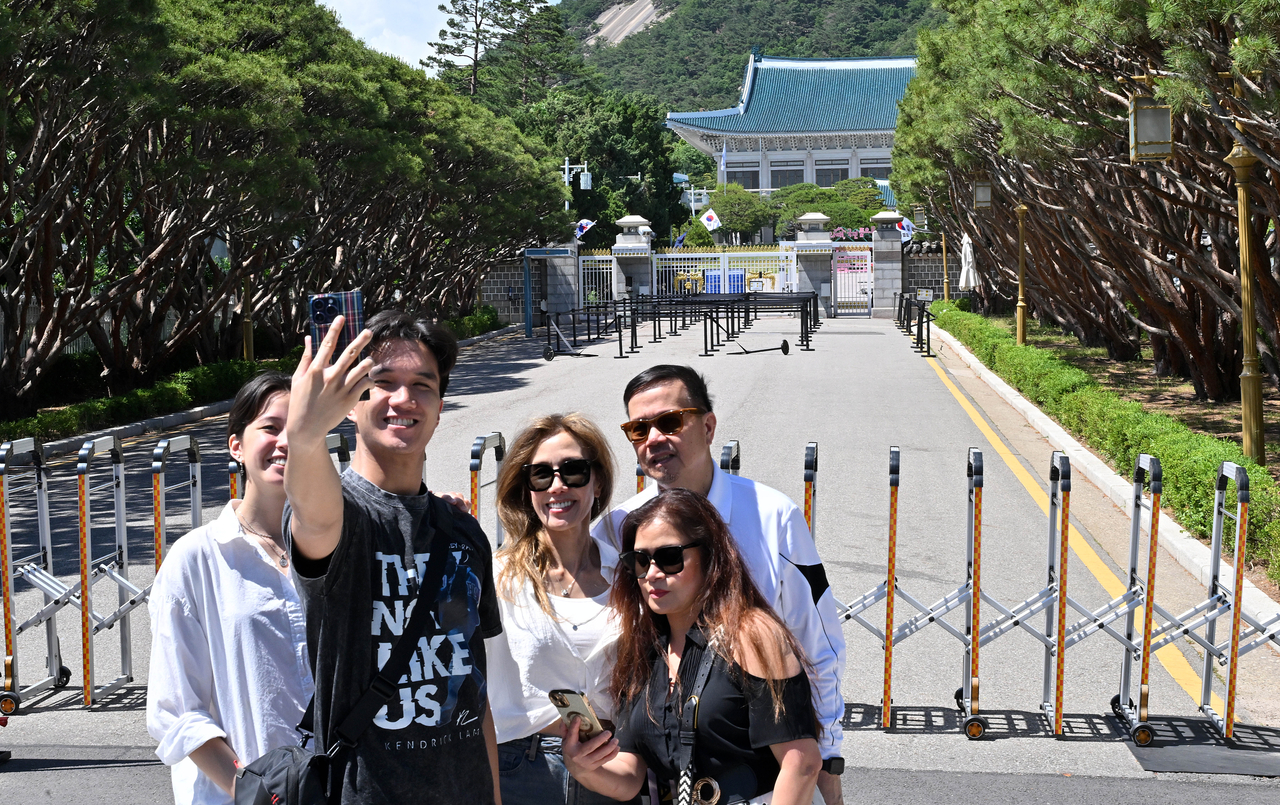 Visitors take photos in front of Cheong Wa Dae, the former presidential office and residence, in Jung-gu, Seoul, Wednesday. (Im Se-jun/The Korea Herald)