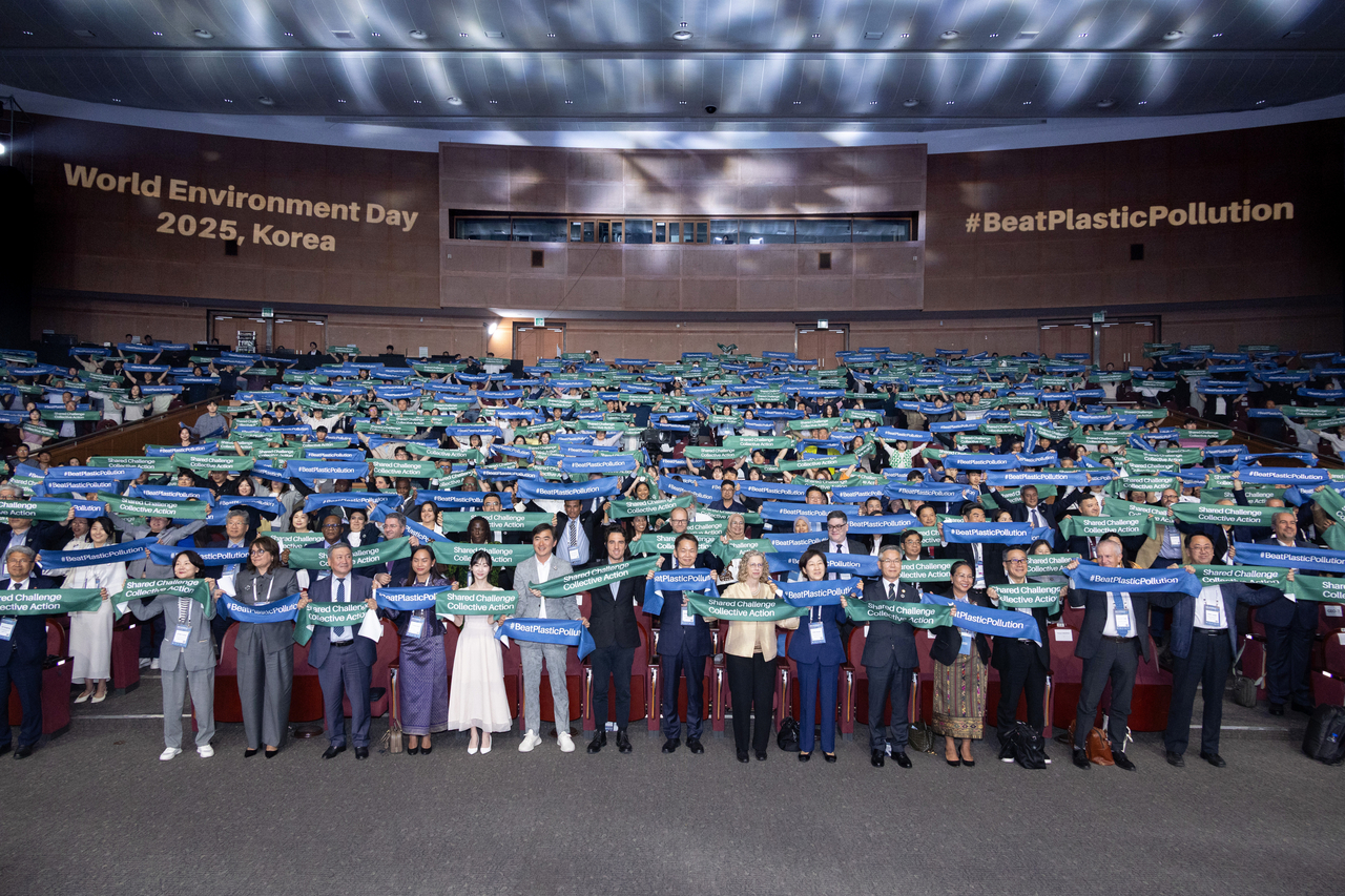 Participants of the World Environment Day 2025 commemorative ceremony hold up banners with the event’s slogans: “Beat Plastic Pollution” and “Shared Challenge Collective Action” at ICC Jeju in Seogwipo, Jeju Island, Thursday. (Ministry of Environment)