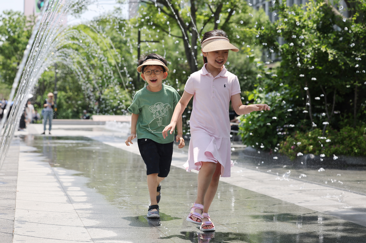 Children cool off in a fountain tunnel at Seoul's Gwanghwamun Square in central Seoul on Thursday. (Yonhap)