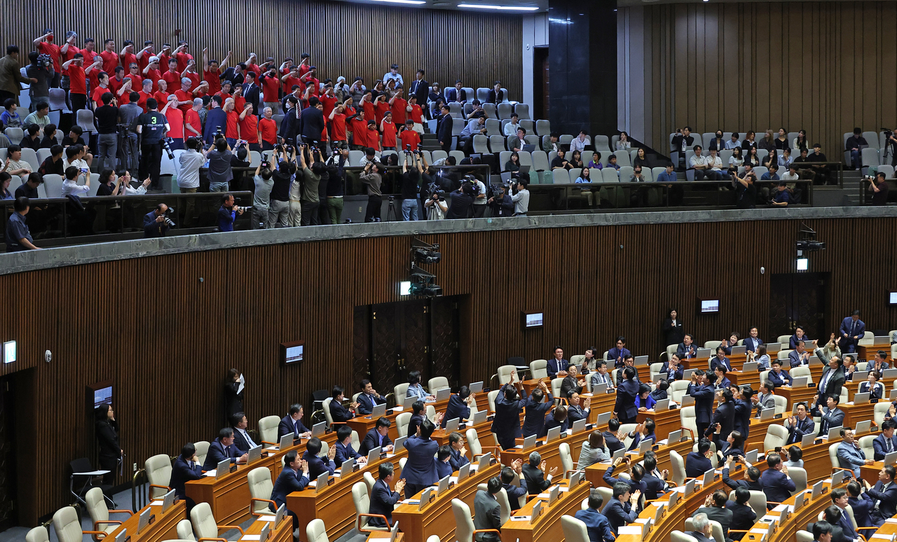 Marine reservists salute at the National Assembly compound after a special counsel probe bill into the death of young Marine passed the parliamentary vote on Thursday. The bill aims to launch an investigation into the allegations that the Yoon administration inappropriately interfered in the military's investigation into a Marine's death during a search mission in July 2023. Yonhap