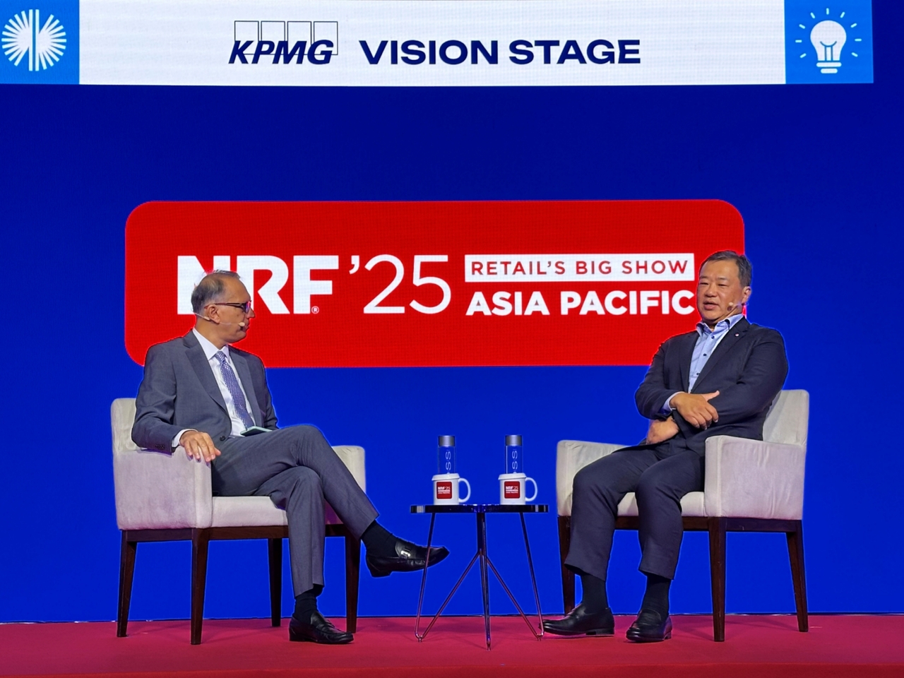 Lotte Shopping Vice Chair Kim Sang-hyun (right) and FairPrice Group CEO Vipul Chawla have a discussion at Marina Bay Sands in Singapore on Tuesday. (Lotte Shopping)