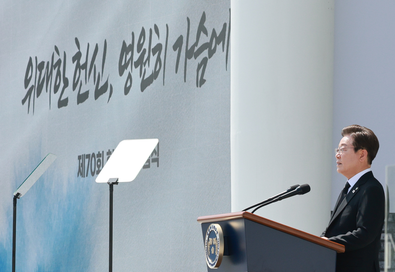 President Lee Jae-myung delivers a memorial address at the 70th Memorial Day ceremony at Seoul National Cemetery on Friday. The banner behind him reads, “Great Devotion, Forever in Our Hearts.” (Pool Photo via Yonhap)