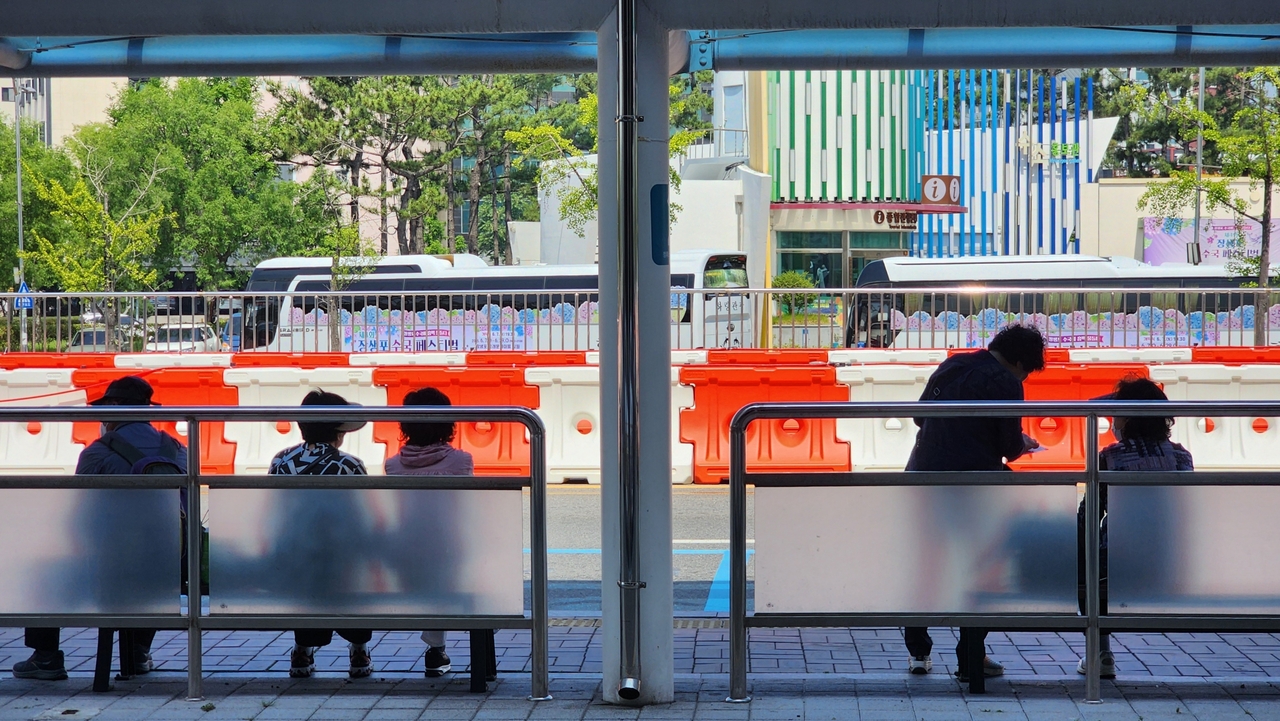 People waiting for a bus at a stop near Taehwagang station in Ulsan, about 300 kilometers southeast of Seoul on Saturday. (Yonhap)