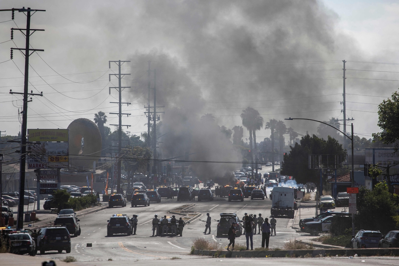 Law enforcement clashes with demonstrators during a protest following federal immigration operations, in the Compton neighborhood of Los Angeles, California on Saturday. (AFP-Yonhap)