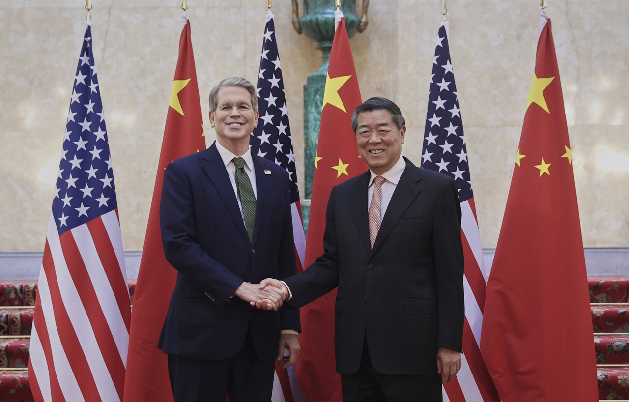 Chinese Vice Premier He Lifeng (right) shakes hands with US Treasury Secretary Scott Bessent before their meeting to discuss China-US trade in London on Monday.   Xinhua-Yonhap