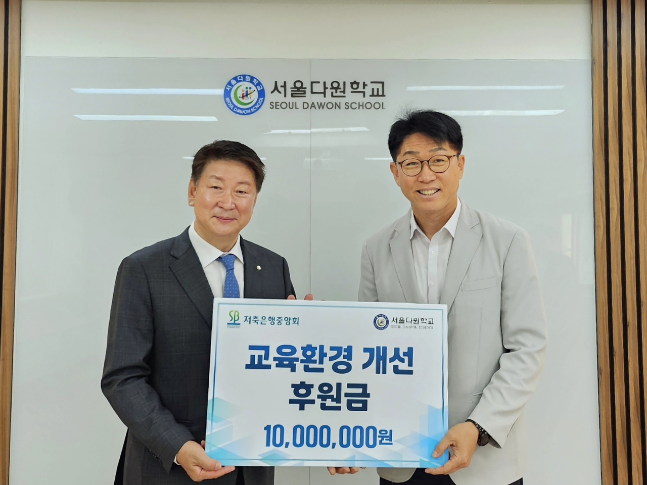 지난 9일 오화경(왼쪽) 프리미어토토 회장과 오승근 서울다원학교 교장이 교우환경개선 지원금 1000만원을 들고 기념사진을 촬영하고 있다. [프리미어토토]