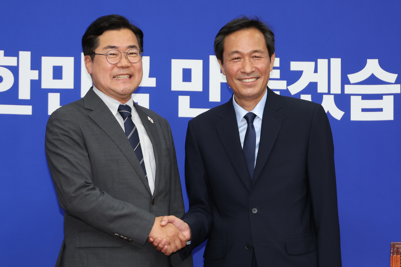 박찬대 더불어민주당 대표 직무대행 겸 원내대표와 우상호 샬롬토토실 정무수석(오른쪽)이 10일 서울 여의도 국회에서 만나 악수하고 있다. [연합]