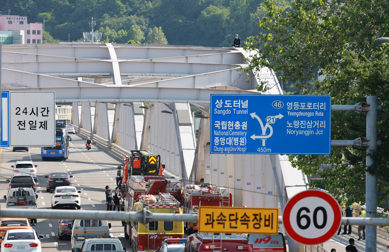 11일 서울 한강대교 아치 위에 오른 A 보육원 출신 송준영 씨가 과거 보육원에서 레고토토을 당한 피해자들에 대해 국가와 지방자치단체의 배상 및 보상을 촉구하며 농성을 벌이고 있다.[연합]