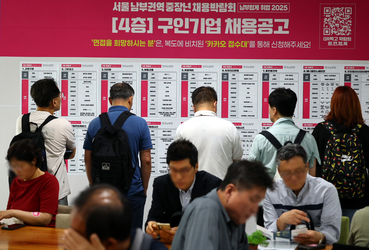 Job seekers are checking job postings at an employment center in Seoul, on Tuesday. (Newsis)