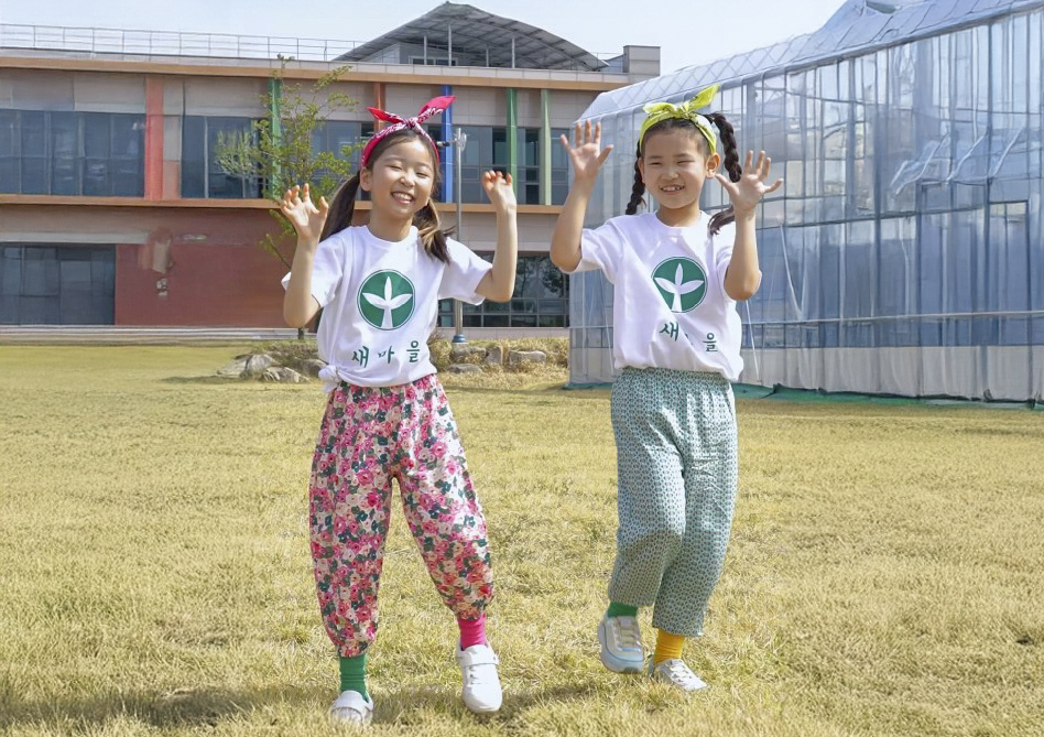 몸빼바지에 새마을 티셔츠를 입고‘건강담은 골드문 토토사이트 추천 챌린지’ 안무를 선보이는 김우리(오른쪽)양과 김민서(왼쪽)양.[칠곡군 제공]
