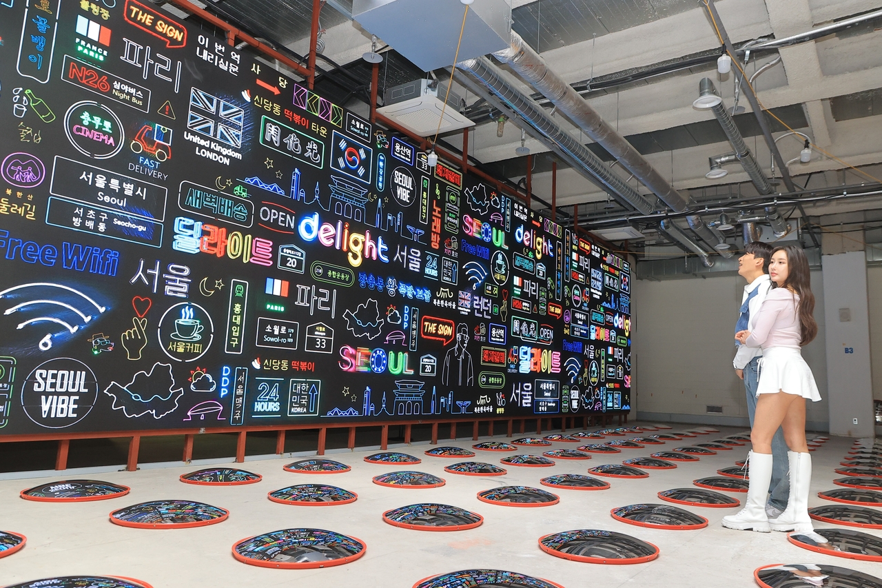 Neon-lit graphics reinterpret Seoul’s urban landscape at Delight Seoul 2025, a digital art exhibition running from May 8 to Nov. 15 at Dohwaseogil D1 in central Seoul. The scene shown was part of a staged media preview held before opening to the public. (Yonhap)