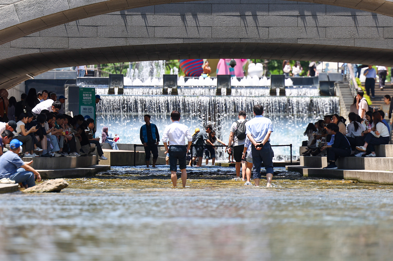 Citizens cool off by the waterfall at Cheonggyecheon in central Seoul on Wednesday. (Yonhap)