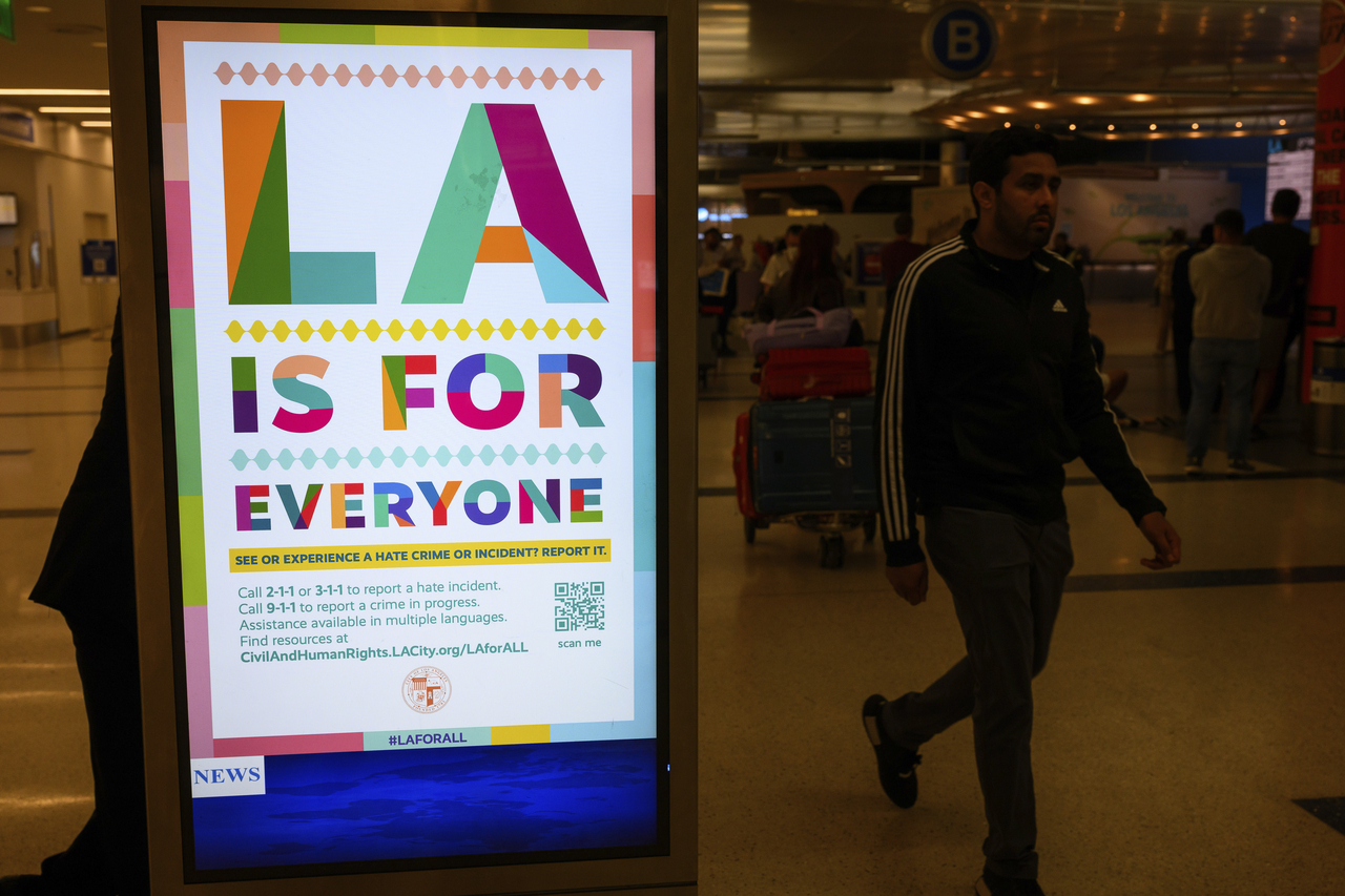 Travelers pass a sign that reads, “LA is for everyone,” in the international arrivals area at the Los Angeles International Airport in Los Angeles, Saturday, June 8, 2025. (AP Photo/William Liang)