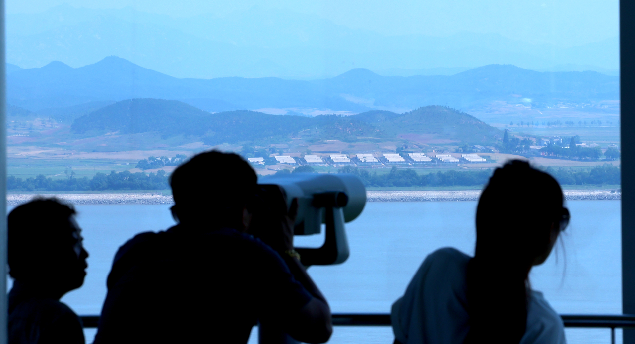 Visitors use binoculars to look at a view of the Kaepung village, a North Korean town, located on the inter-Korean border, from South Korea’s Ganghwa Peace Observatory in Ganghwa County, Incheon, Thursday. (Yonhap)