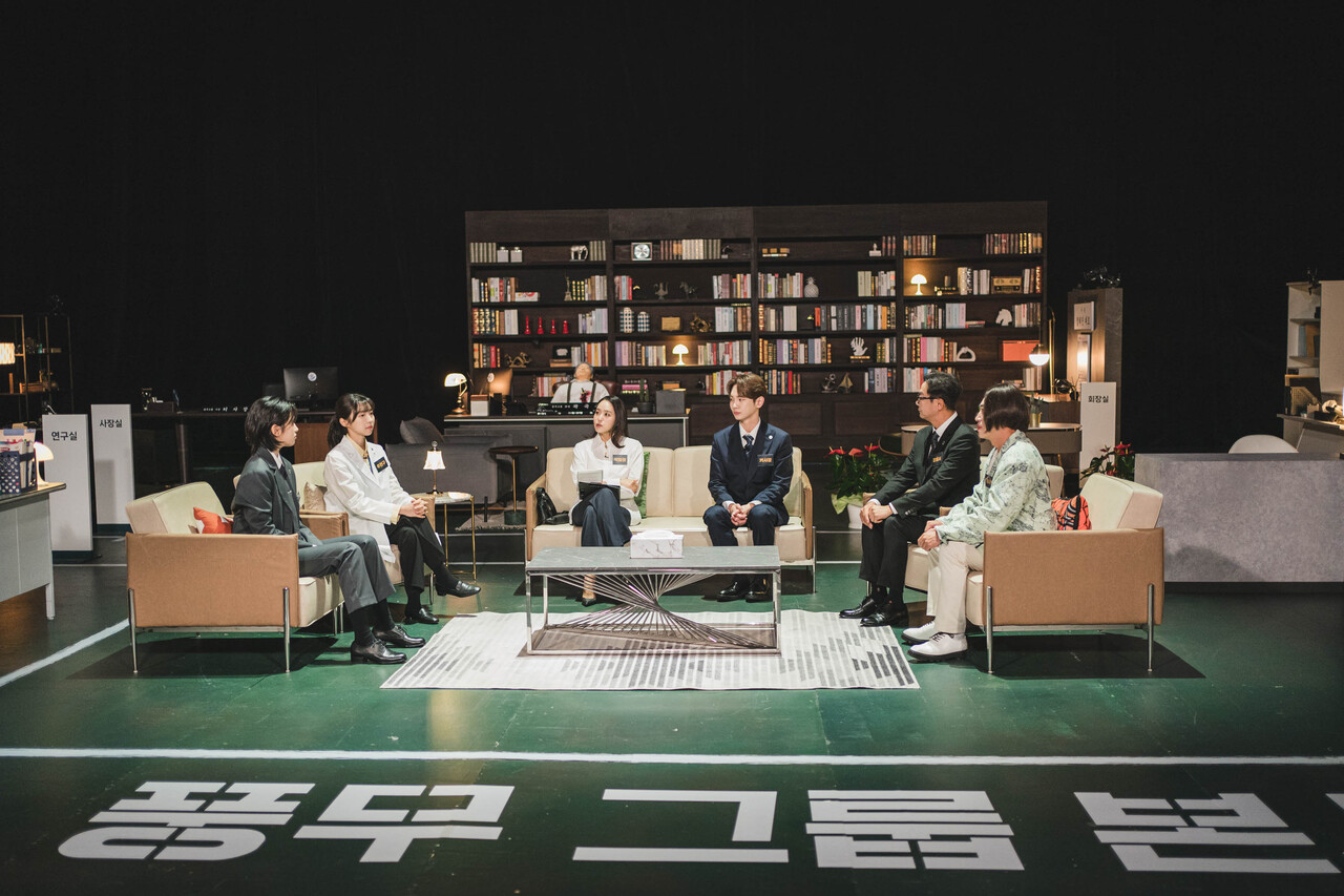 Cast members of Tving’s "Crime Scene Returns" sit in a half-circle during a scripted murder investigation in this still from episodes 9 and 10. (Tving)