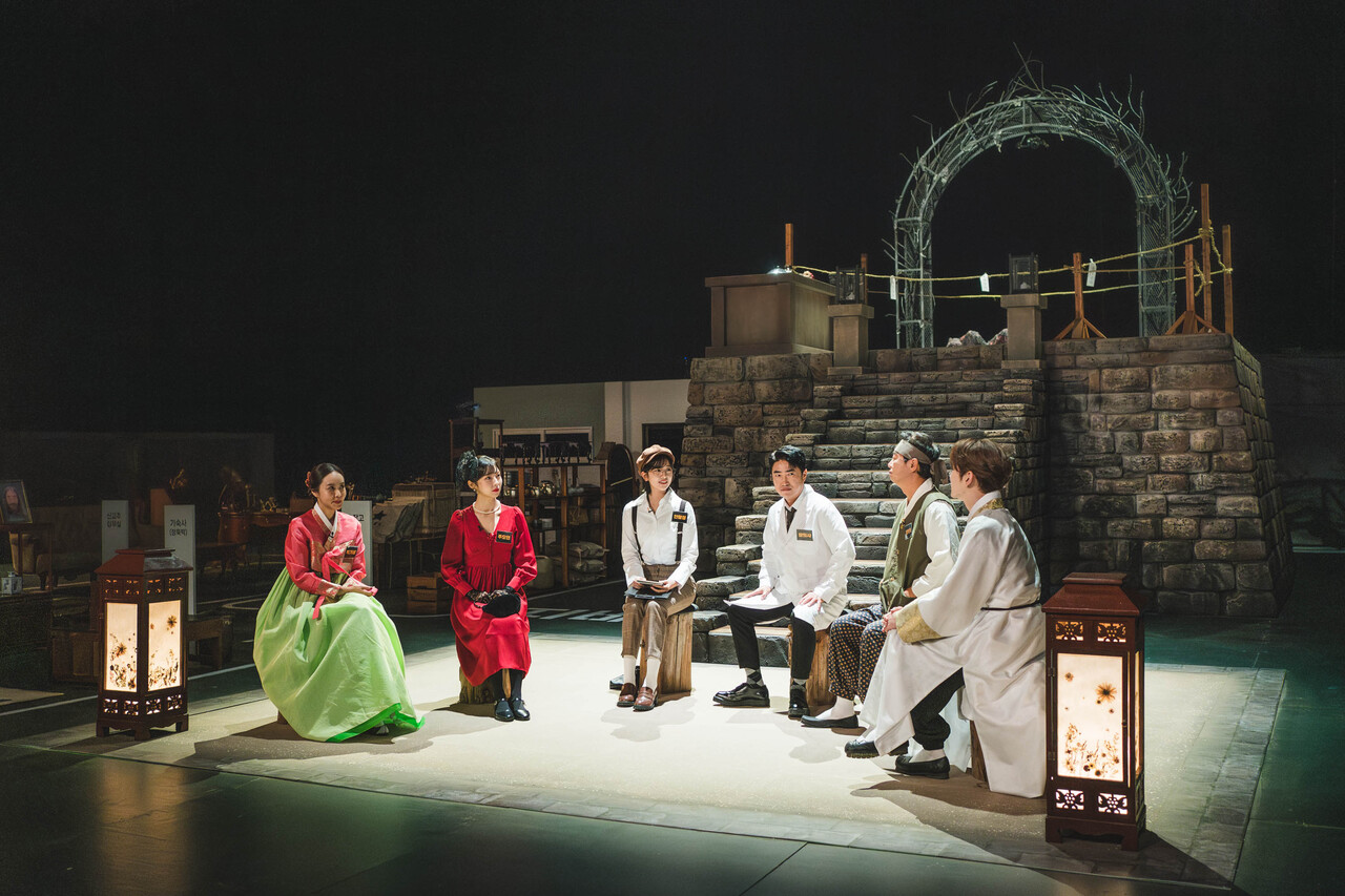 Cast members of Tving’s "Crime Scene Returns" sit in a half-circle during a scripted murder investigation in this still from episodes 7 and 8. (Tving)