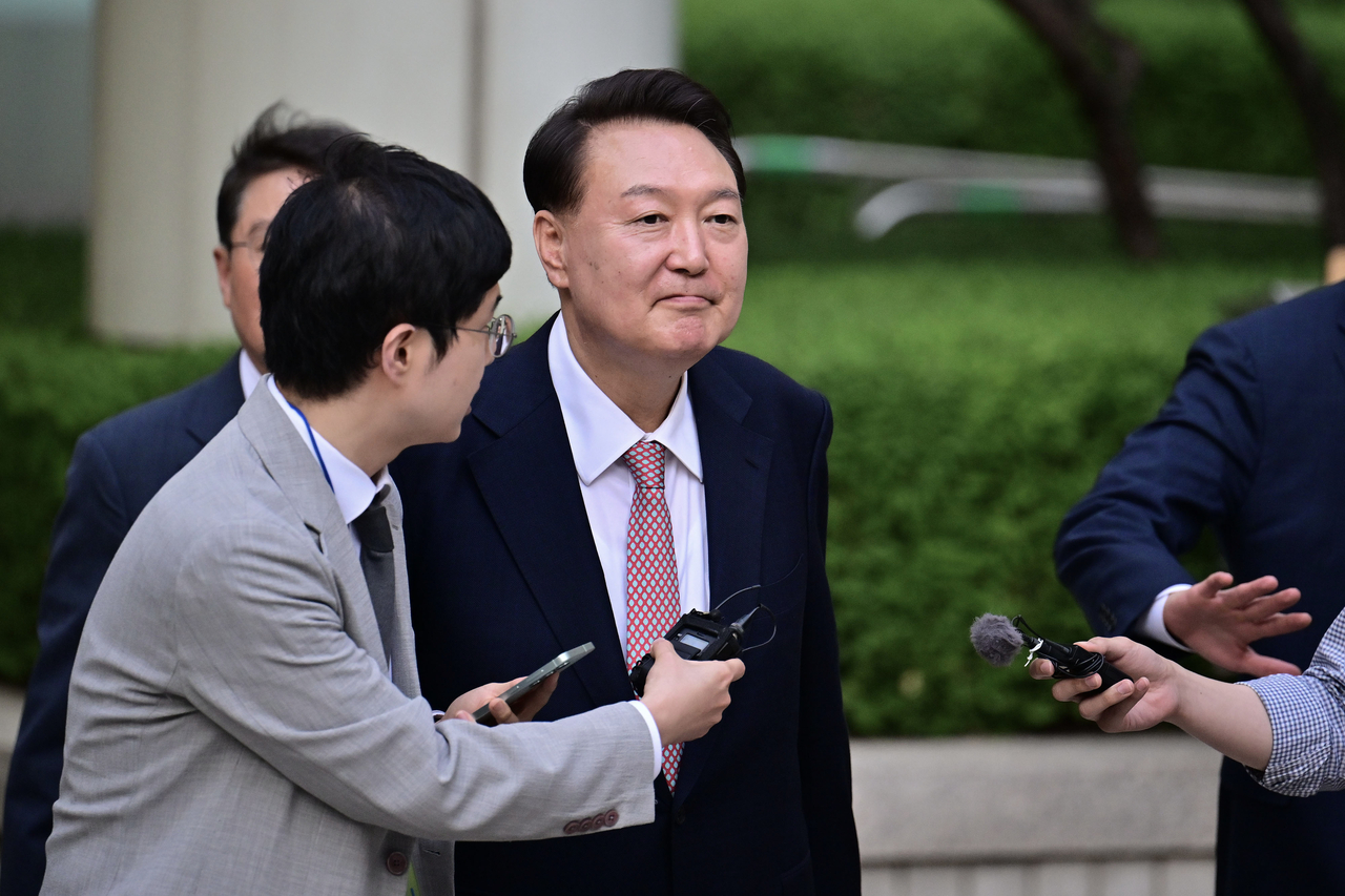 Former President Yoon Suk Yeol (center) exits the Seoul Central District Court in the capital on Monday, after attending the sixth hearing of a trial over insurrection charges in connection with his declaration of martial law. (Yonhap)