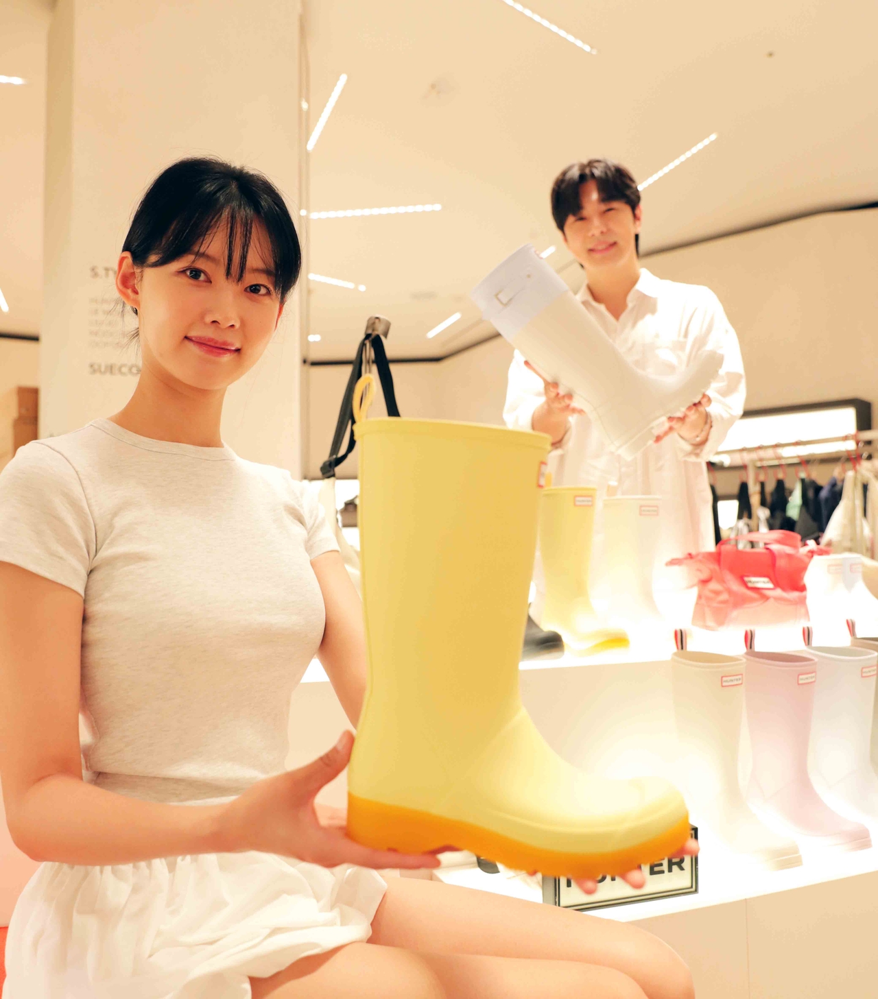 신더블유 토토백화점 강남점 슈즈 매장에서 모델이 장마 관련 아이템을 들고 있는 모습 [신더블유 토토백화점 제공]