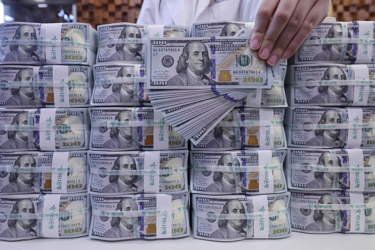 A banker checks dollars at Hana Bank's Counterfeit Notes Response Center in Seoul on June 5. (Yonhap)