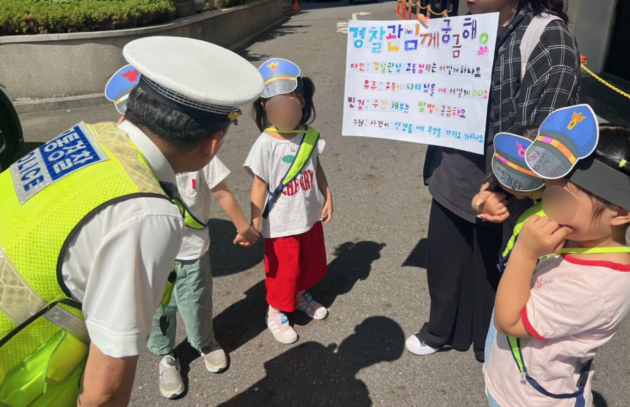 지난 11일 오전 10시께 교통경찰이 서울 종로더블유 토토 관내에 있는 어린이집 학생들에게 질문을 받고 있다. [종로더블유 토토 제공]