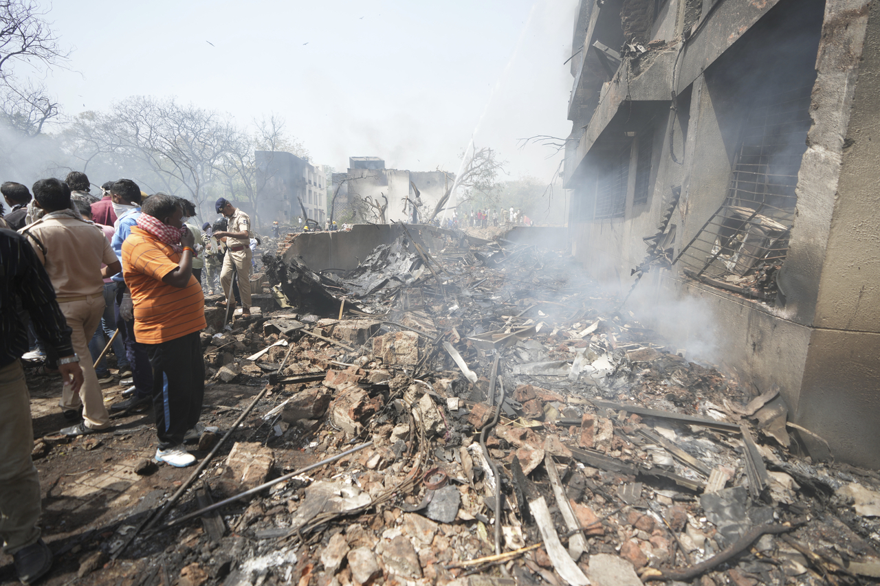 People stand around debris at the site of an airplane that crashed in India's northwestern city of Ahmedabad in Gujarat state, Thursday, June12, 2025. (AP-Yonhap)