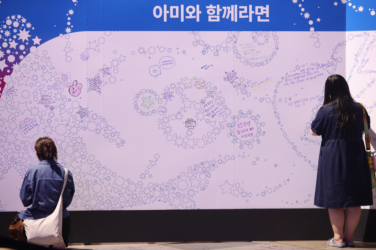 BTS fans leave messages on a white wall at the 2025 BTS Festa held at Kintex in Goyang, Gyeonggi Province, on June 13. (Yonhap)