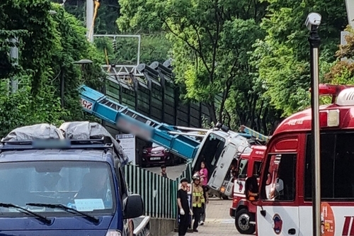 This photo, provided by a reader, shows a ladder truck that has fallen onto its side with the ladder extending over the power supply system of the Gyeongui-Jungang Line in western Seoul on June 13, 2025. (Yonhap)