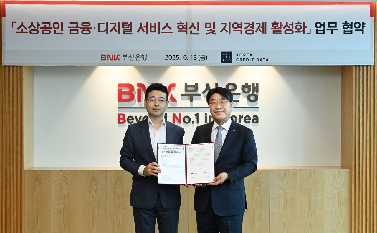 방성빈 BNK부산은행 은행장, 김동호 한국신용데이터 대표가 13일 오전 문현동 본점에서 소상공인 올림피아토토과 지역경제 활성화를 위한 전략적 업무협약을 체결한 뒤 기념사진을 촬영하고 있다. [BNK부산은행 제공]
