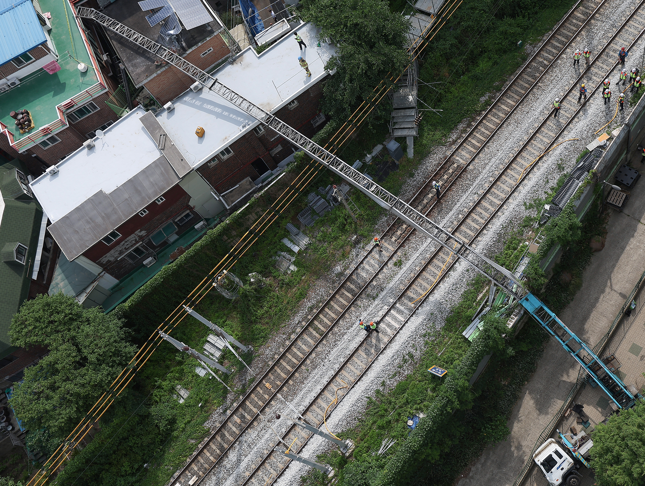 This photo, provided by a reader, shows a ladder truck that has fallen onto its side with the ladder extending over the power supply system of the Gyeongui-Jungang Line in western Seoul on June 13, 2025. (Yonhap)