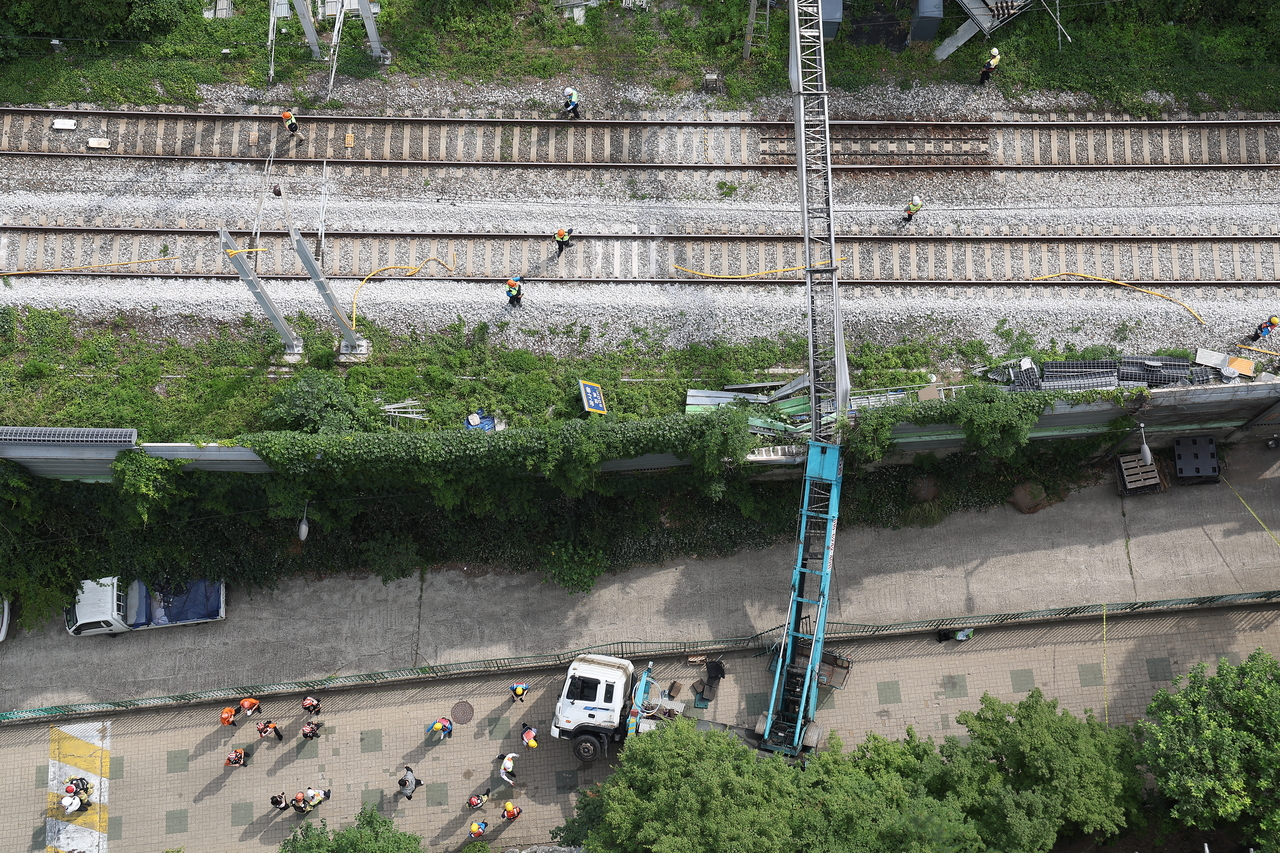 This photo, provided by a reader, shows a ladder truck that has fallen onto its side with the ladder extending over the power supply system of the Gyeongui-Jungang Line in western Seoul on June 13, 2025. (Yonhap)