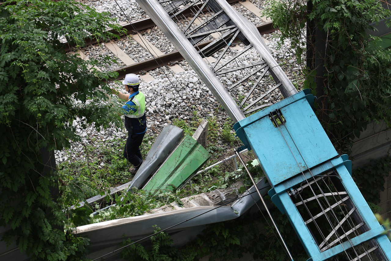 This photo, provided by a reader, shows a ladder truck that has fallen onto its side with the ladder extending over the power supply system of the Gyeongui-Jungang Line in western Seoul on June 13, 2025. (Yonhap)