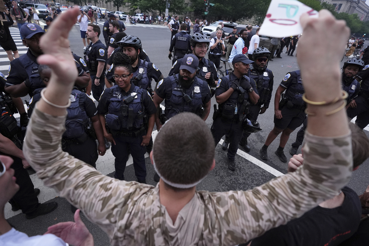 A demonstrator chants while facing members of the D.C. Metropolitan Police during a protest taking place on the day of a military parade commemorating the Army's 250th anniversary, coinciding with President Donald Trump's 79th birthday, Saturday, in Washington. (AP-Yonhap)
