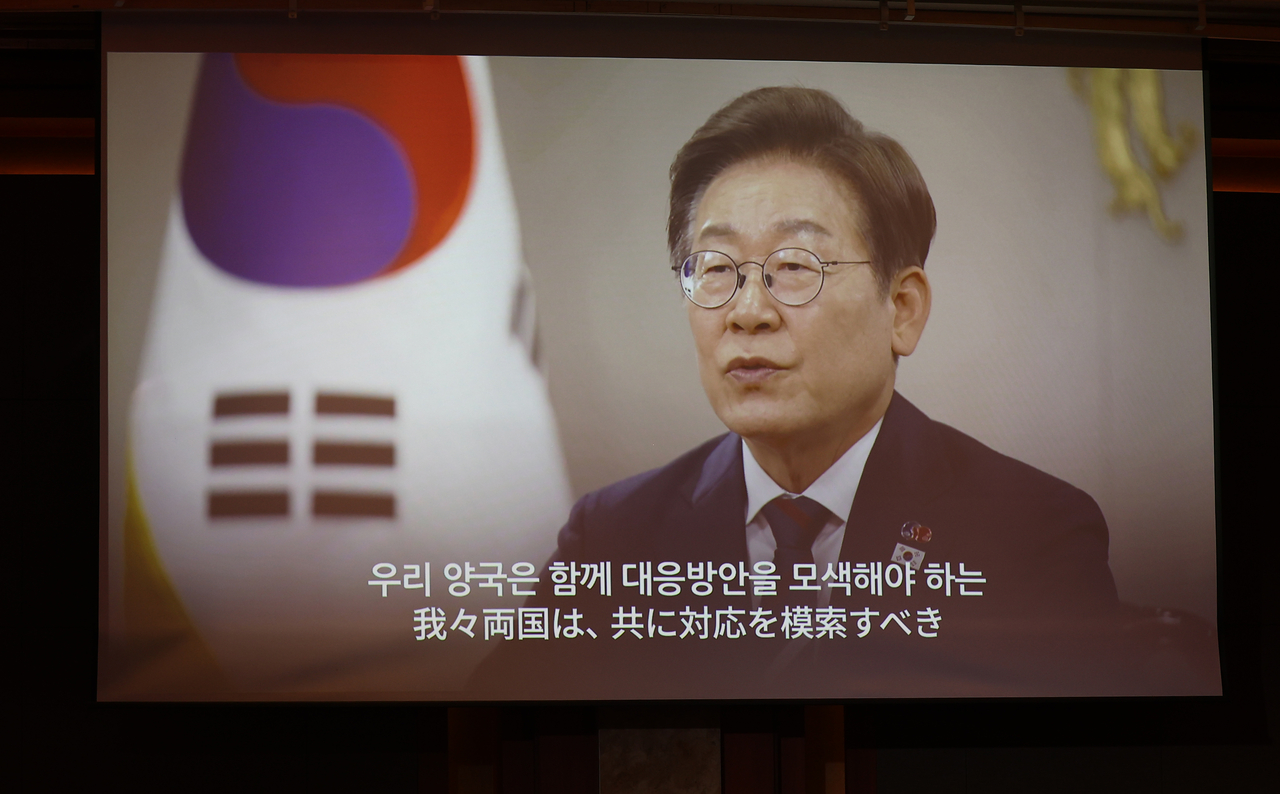 President Lee Jae-myung delivers a video message to guests during a reception marking the 60th anniversary of the establishment of diplomatic ties between South Korea and Japan, held at Lotte Hotel in Seoul on June 16. (Yonhap)