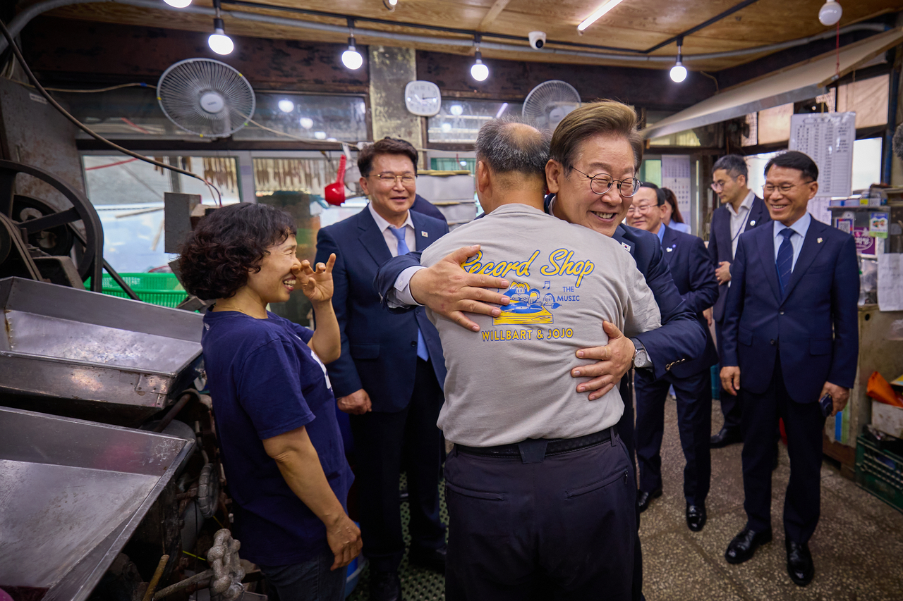 President Lee Jae-myung embraces a resident during his visit to Yeoncheon-gun, Gyeonggi Province, on Friday. (Yonhap)