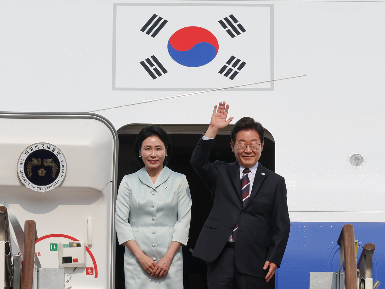 President Lee Jae-myung and first lady Kim Hye-kyung wave before boarding Air Force One at Seoul Air Base in Seongnam, Gyeonggi Province, on Monday afternoon. (Yonhap)