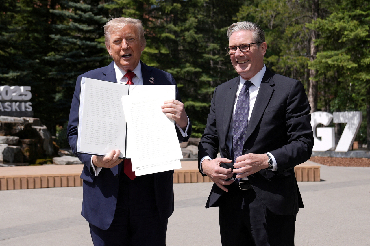 US President Donald Trump (left) holds a signed Trade Agreement with Britain during a meeting with British Prime Minister Keir Starmer, at the G7 summit, in Kananaskis, Alberta, Canada, Monday.   Reuters-Yonhap