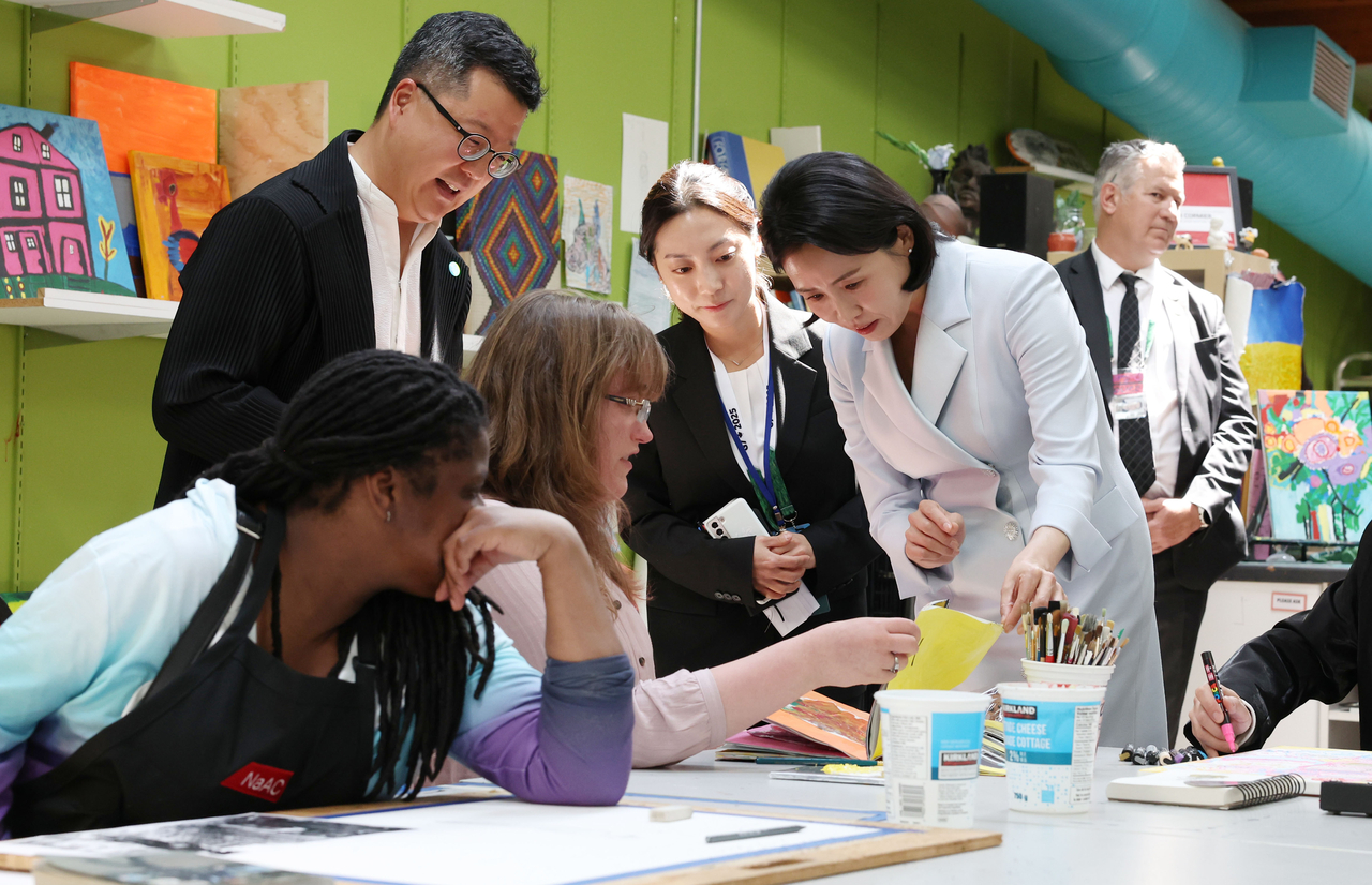 First lady Kim Hea Kyung views a piece of artwork by a center artist during her visit to the National accessArts Centre in Calgary, Alberta, Canada, on Tuesday. (Yonhap)