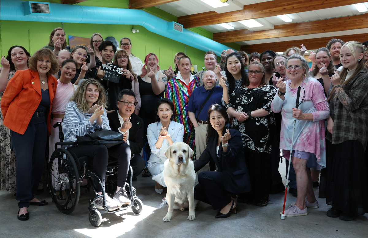 First lady Kim Hye-kyung (center) poses with artists with disabilities and Bella, a retired guide dog, during her visit to the National accessArts Centre in Calgary, Canada, on Tuesday. (Yonhap)