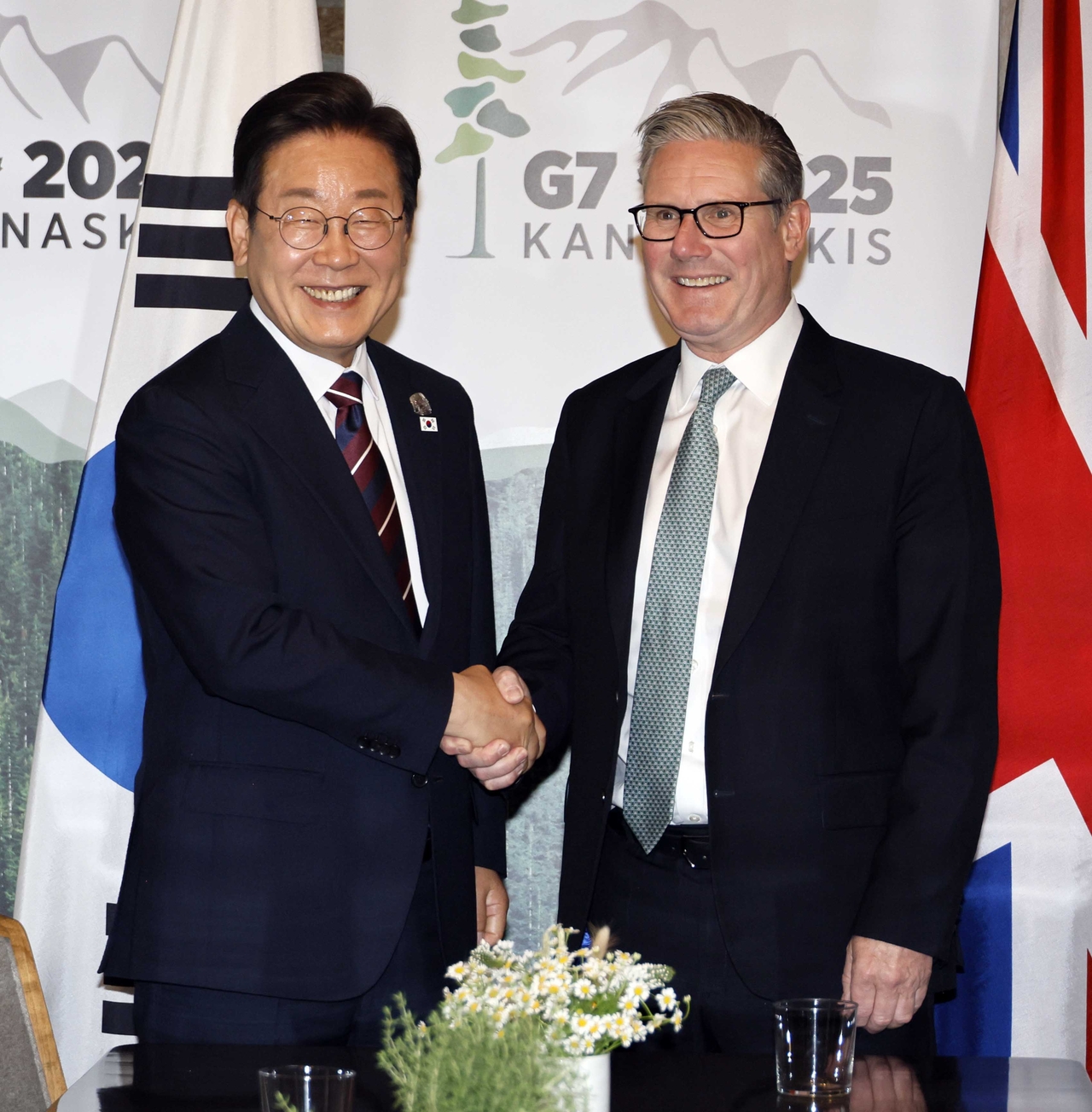 President Lee Jae Myung (left) and UK Prime Minister Keir Starmer shake hands during a bilateral meeting on the sidelines of G7 summit in Canada on Tuesday. (Yonhap)