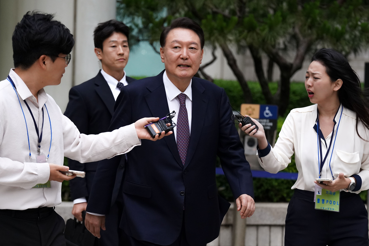 Former President Yoon Suk Yeol (center) exits the Seoul Central District Court in the capital on Monday, after attending the 7th hearing of a trial over insurrection charges in connection with his declaration of martial law. (Yonhap)