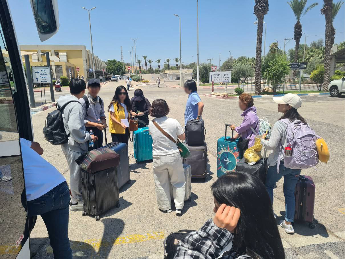 South Korean nationals stand by to board a chartered bus at an assembly point in Israel on Thursday, ahead of their evacuation to Jordan. (Ministry of Foreign Affairs)