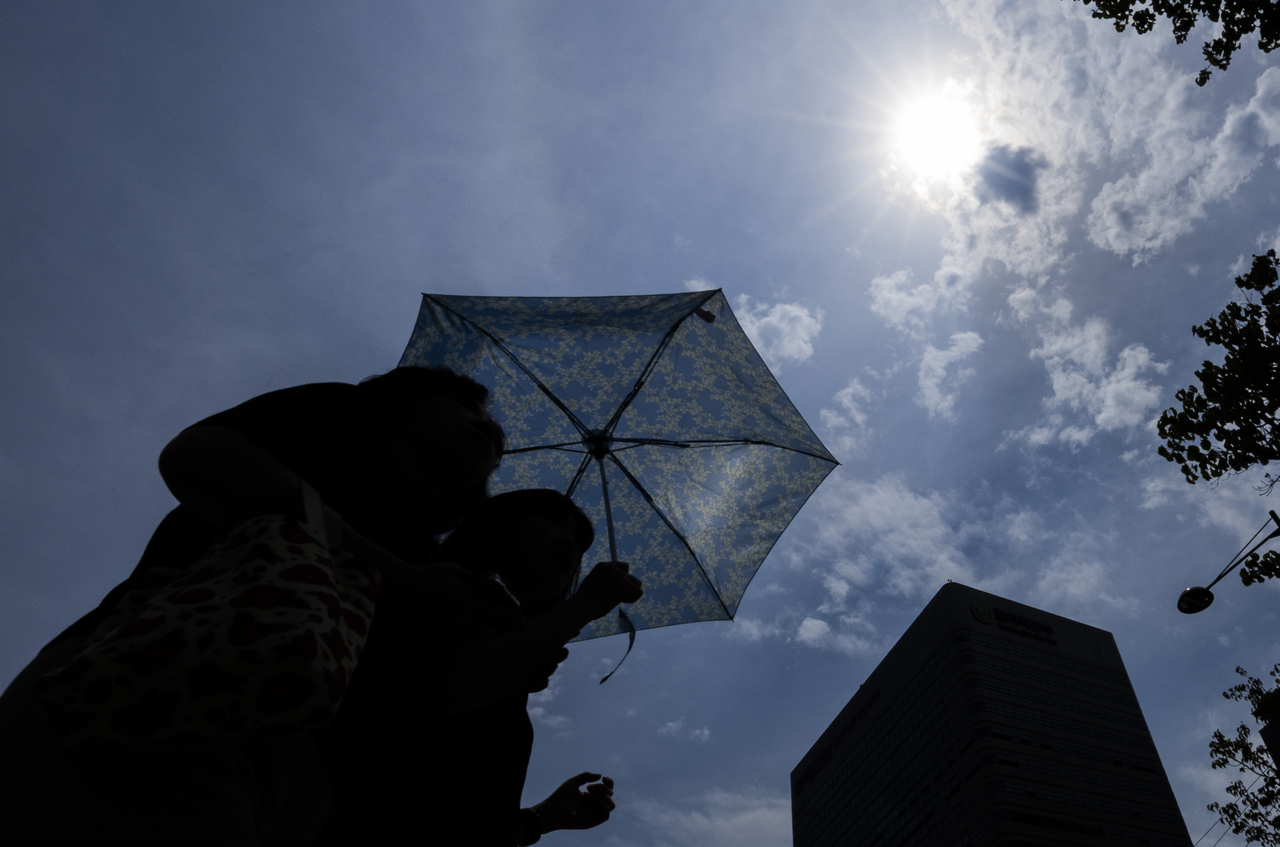 Pedestrians are seen walking under umbrellas at Gwanghwamun Square in Seoul on Thursday. (Yonhap)