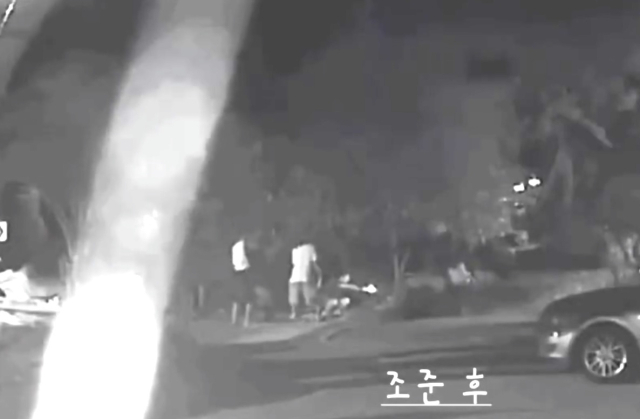 In this screenshot of surveillance camera footage, three men are seen firing BB guns at four dogs that were tied up in front of a restaurant in Geoje, South Gyeongsang Province, on June 8. (Beagle Rescue Network)